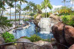 a swimming pool with a waterfall in a resort at Hilton Grand Vacations Club Grand Waikikian Honolulu in Honolulu
