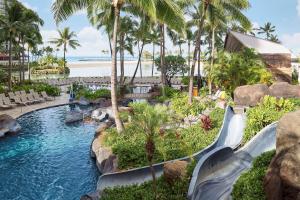a water slide at a resort with palm trees at Hilton Grand Vacations Club Grand Waikikian Honolulu in Honolulu