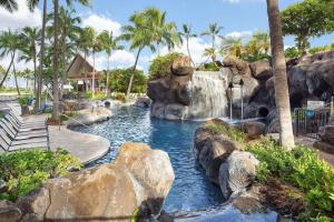 a swimming pool with a waterfall in a resort at Hilton Grand Vacations Club Grand Waikikian Honolulu in Honolulu