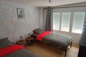 een slaapkamer met 2 aparte bedden en een raam bij Duplex Camélia T3 avec jardin in Clohars-Carnoët