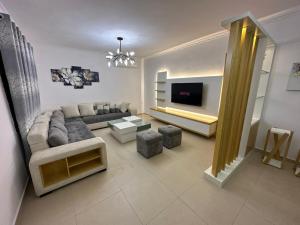 a living room with a couch and a tv at Elby Apartments in Berat