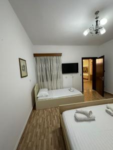 a room with two beds and a flat screen tv at Elby Apartments in Berat
