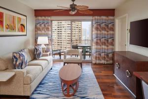 uma sala de estar com um sofá e uma televisão em Hilton Grand Vacations Club Grand Waikikian Honolulu em Honolulu
