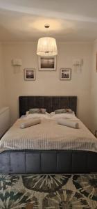 a bedroom with a large bed with a chandelier at Apartament JULIA in Świnoujście