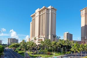 un grand bâtiment dans une ville avec des palmiers dans l'établissement Hilton Grand Vacations Club at Hilton Hawaiian Village, à Honolulu