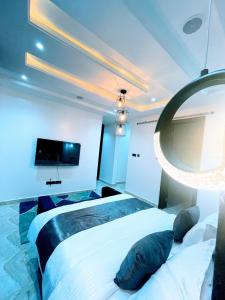 een slaapkamer met 2 bedden en een grote spiegel bij Contemporary 4-Bedroom Villa with VR Room and Starlink Internet - Ifemide Estates in Akure