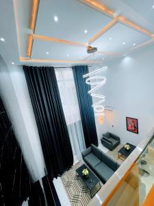 a living room with a couch and a window at Contemporary 4-Bedroom Villa with VR Room and Starlink Internet - Ifemide Estates in Akure