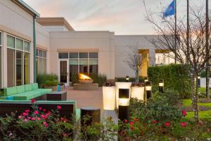 a building with a courtyard with flowers and plants at Hilton Garden Inn Houston NW America Plaza in Houston