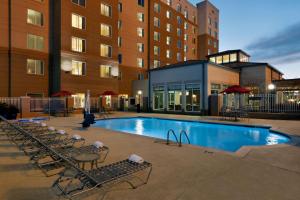 a swimming pool with chairs and a building at Hilton Garden Inn Houston NW America Plaza in Houston