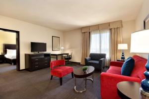 a hotel room with a living area with red furniture at Hilton Garden Inn Houston NW America Plaza in Houston