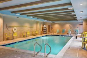 una piscina en un hotel con mesas y sillas amarillas en Home2 Suites At The Galleria en Houston