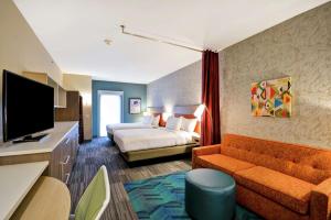 休斯顿Home2 Suites At The Galleria的配有床和电视的酒店房间