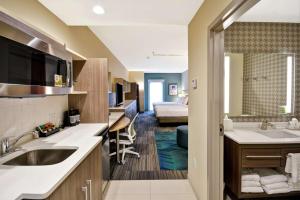 休斯顿Home2 Suites At The Galleria的带水槽的厨房和1间带床的房间
