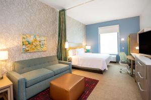 um quarto de hotel com uma cama e um sofá em Home2 Suites by Hilton Houston Bush Intercontinental Airport Iah Beltway 8 em Houston