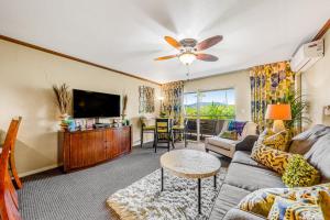 a living room with a couch and a flat screen tv at Plantation Hale J11 in Kapaa