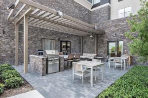 patio ze sprzętem do grillowania, stołami i krzesłami w obiekcie Homewood Suites By Hilton Houston Memorial w mieście Houston