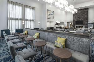 a lobby with a bar with stools and tables at Homewood Suites By Hilton Houston Memorial in Houston