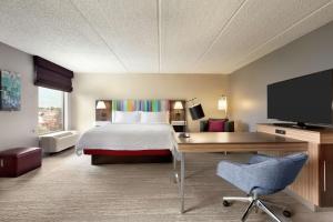 Habitación de hotel con cama, escritorio y TV. en Hampton Inn - Houston/Brookhollow, en Houston