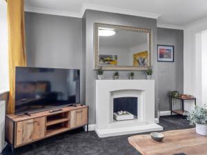 a living room with a fireplace and a mirror at Mountain View Beautiful Large House By Cockermouth in Cockermouth