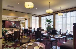 um restaurante com mesas, cadeiras e janelas em Hilton Garden Inn Houston-Pearland em Pearland