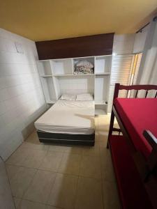 um pequeno quarto com uma cama num quarto em Kitnets Itapuã Residência - 1 Minuto de Caminhada Ate a Praia em Salvador