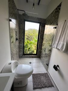 a bathroom with a toilet sink and a window at Glamping La Montañita in Medellín