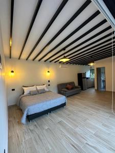 - une grande chambre avec un lit et un canapé dans l'établissement Glamping La Montañita, à Medellín