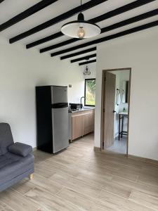 a kitchen with a couch and a refrigerator in a room at Glamping La Montañita in Medellín