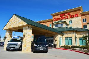 two trucks are parked in front of a garage at Hilton Garden Inn Houston West Katy in Katy