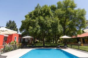 a swimming pool in front of a house with trees at Hotel Boutique Rancho San Juan Teotihuacan in San Juan Teotihuacán