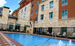 a swimming pool in front of a building at Hilton Garden Inn Houston West Katy in Katy