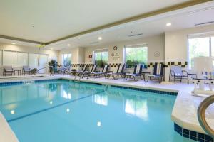 une grande piscine avec des chaises et des tables dans l'établissement Hilton Garden Inn Nanuet, à Nanuet