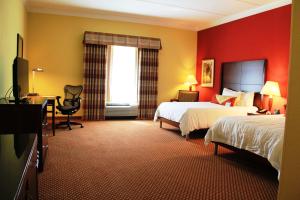 a hotel room with two beds and a desk at Hilton Garden Inn Houston West Katy in Katy