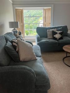 a living room with a blue couch and a window at Beachglass in Lynton