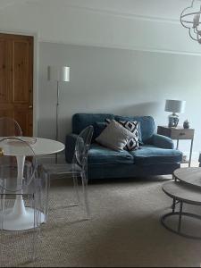 a living room with a blue couch and tables at Beachglass in Lynton