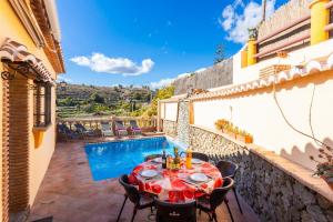 a patio with a table and chairs next to a pool at Villa Las Palomas 2 in Frigiliana