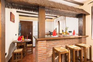un bar en una cocina con taburetes de madera en Villa Las Palomas 2 en Frigiliana