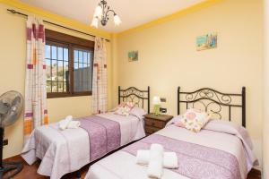 a bedroom with two beds and a window at Villa Las Palomas 2 in Frigiliana +20 photos