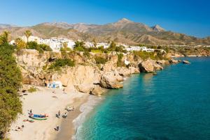 a beach with people on it next to the water at Villa Las Palomas 2 in Frigiliana