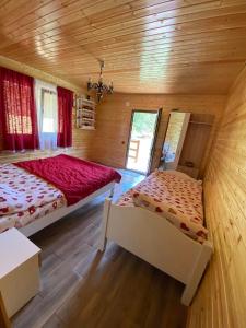 a bedroom with two beds in a wooden cabin at CAMPING THOBIAS in Alunu