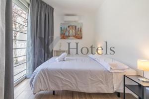 a white bedroom with a bed and a large window at AYZ Joaquín Pol - Auto check-in property in Madrid
