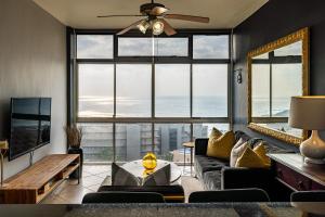 a living room with a couch and a large window at Cosy Sky View Apartment in Ballito