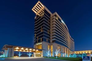 un palazzo alto con luci accese di notte di Hilton Branson Convention Center a Branson