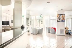 a white kitchen with white chairs and a counter at Hotel Villa Argia Rimini Marina Centro in Rimini