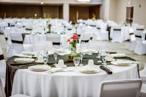 uma sala de jantar com mesas brancas e cadeiras brancas em DoubleTree by Hilton Huntington, WV em Huntington