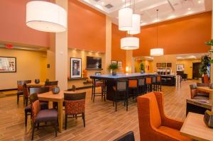 a restaurant with tables and chairs in a room at Hampton Inn & Suites Huntsville in Huntsville