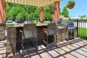 an outdoor bar with chairs and a grill on a patio at Homewood Suites by Hilton Houma in Houma