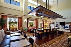 a restaurant with a bar with tables and chairs at Hampton Inn & Suites Morgan City in Morgan City