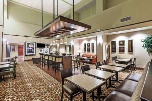 a restaurant with tables and chairs and a bar at Hampton Inn & Suites Morgan City in Morgan City