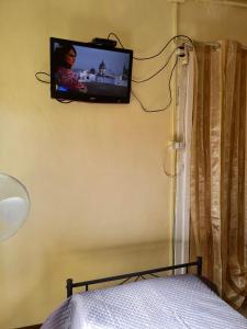 a television on the wall of a bedroom with a bed at La Casa di Emanuela in Caltavuturo